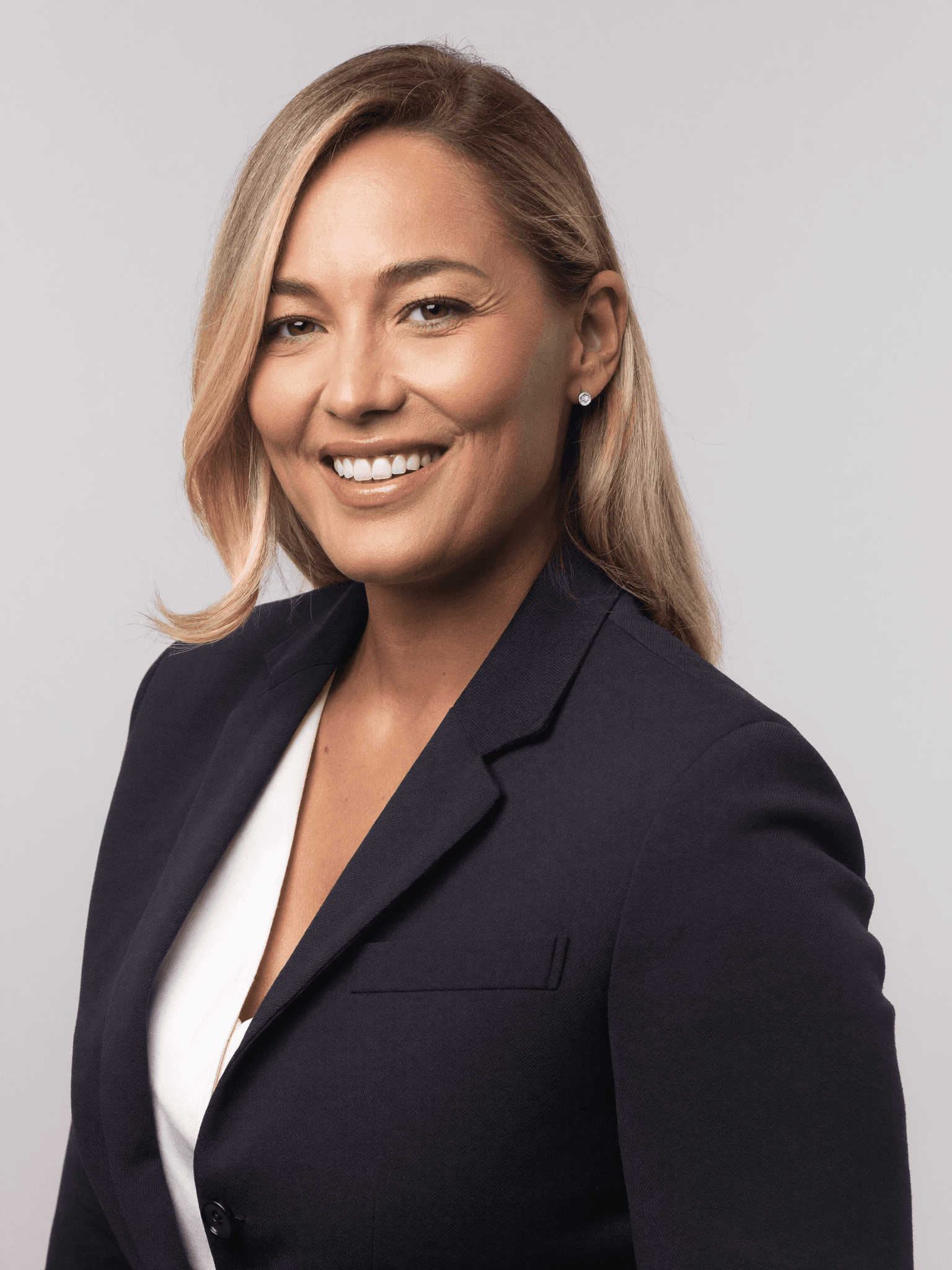 Professional studio headshot of a real estate agent in a navy blazer